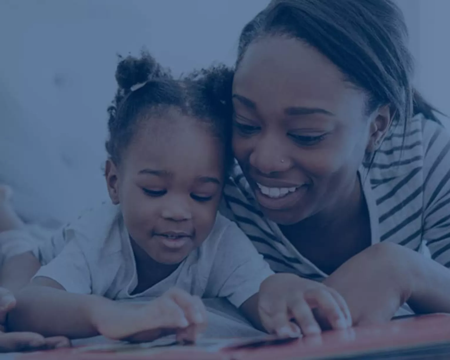 a woman reading a book with a toddler