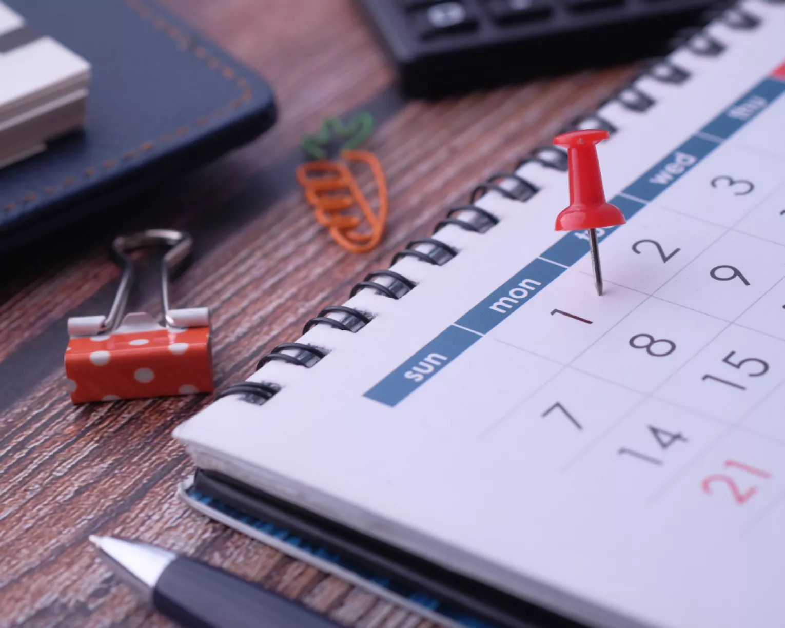 A desk calendar with a pushpin on the first of the month.