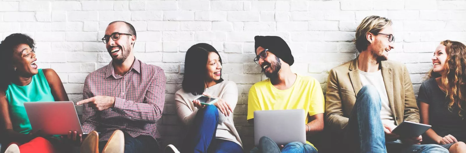 Educators sit against a wall learning together.
