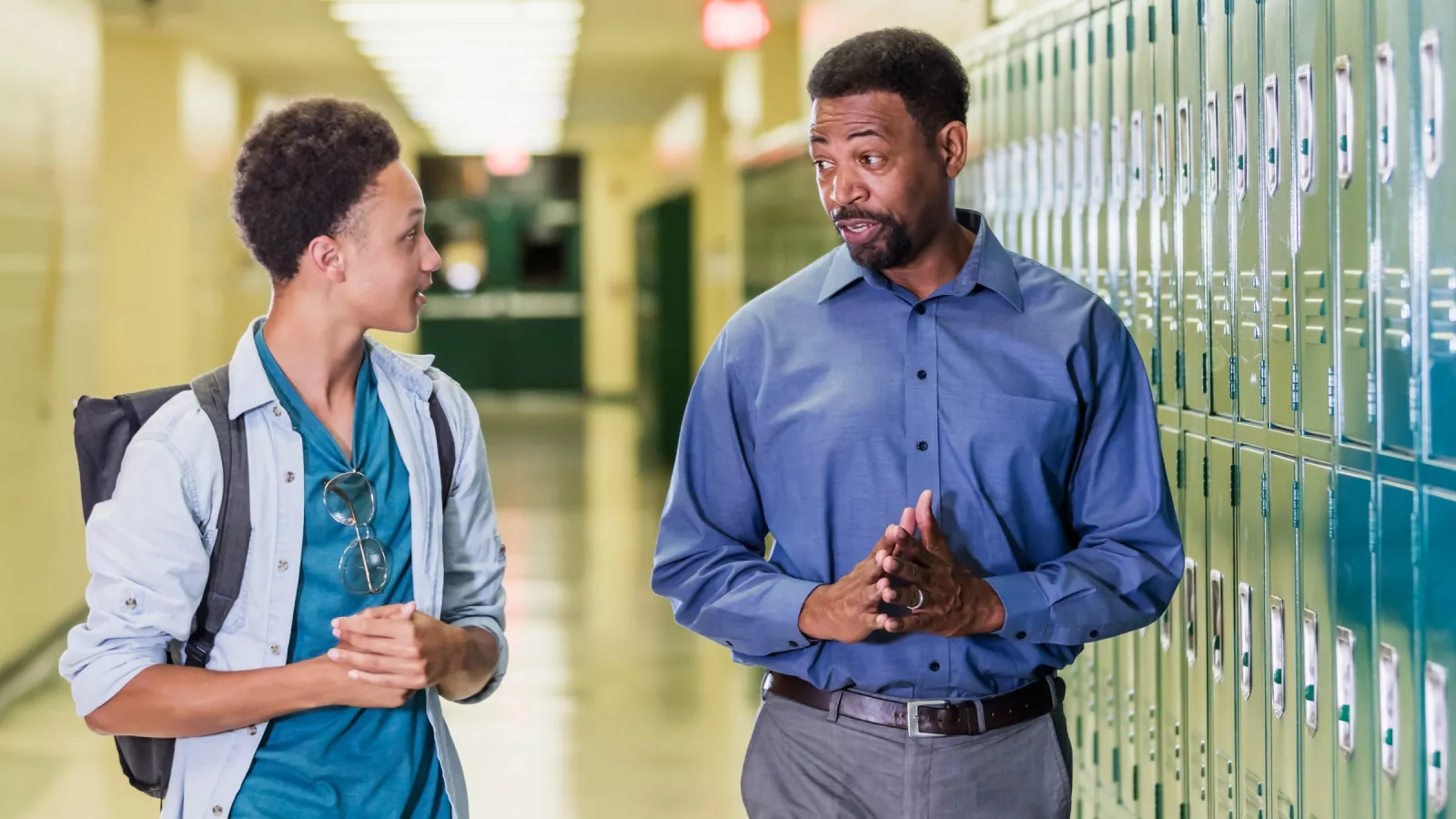 An educator and a student walking in a hallway