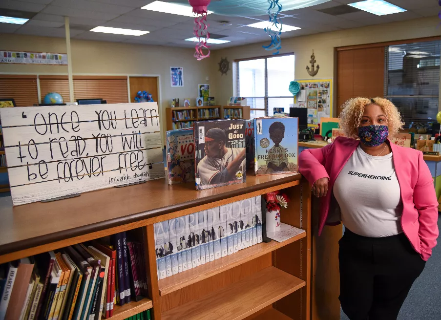 LaToya Morgan poses by bookshelves