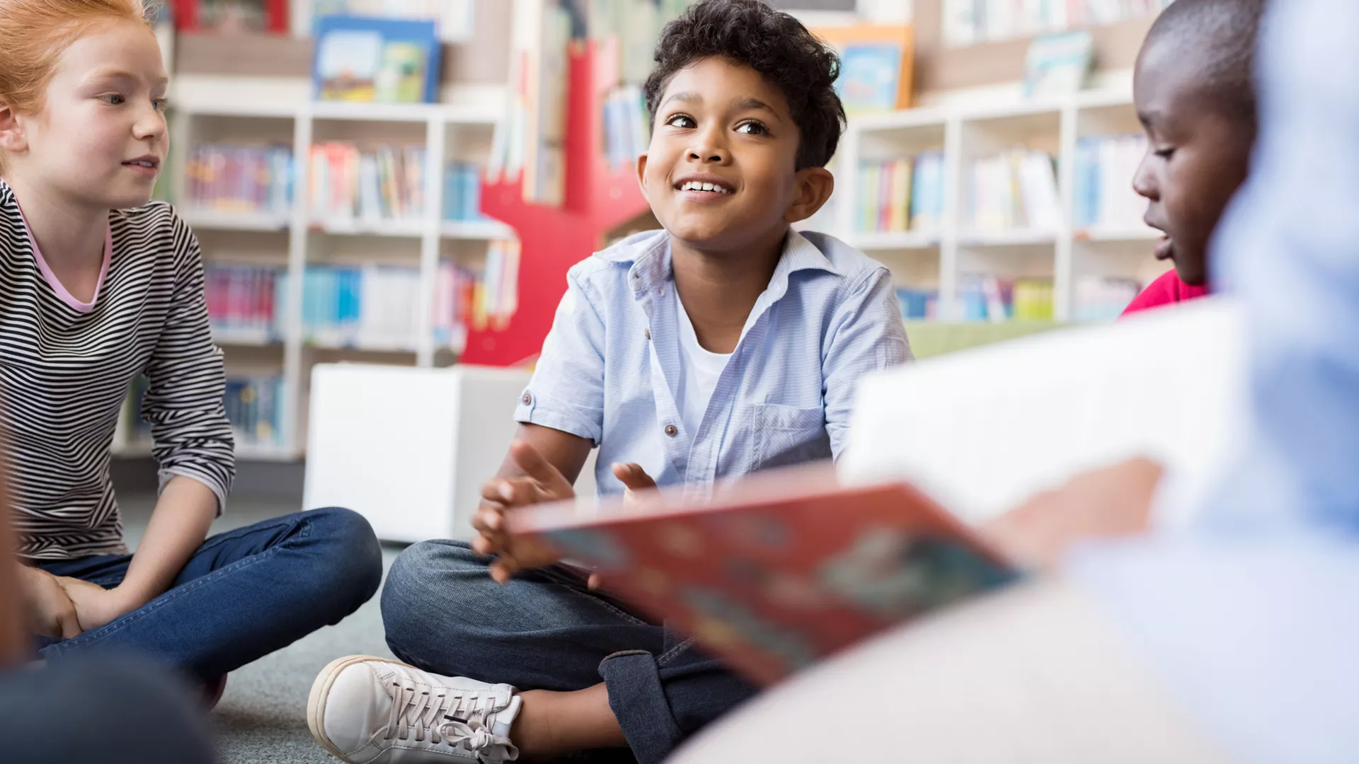 children sitting on the floor of a library listening to stories