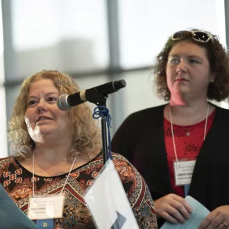 Jennifer Seigal and Tracey Prince at a microphone