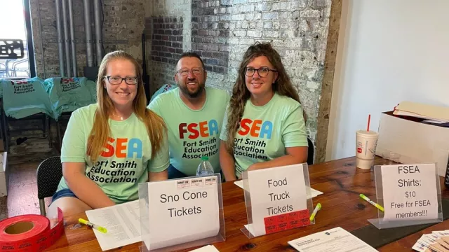 FSEA members at an FSEA table pose for a quick picture